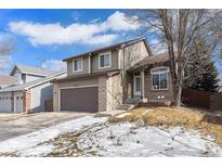 Charming two-story home with brick accents, attached two car garage, and landscaped front yard at 9314 Wiltshire Dr, Highlands Ranch, CO 80130