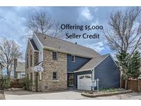 Two-story home featuring a brick facade, blue siding, attached garage, and a basketball hoop on the driveway at 16780 E Hialeah Ave, Centennial, CO 80015