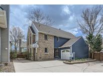 Two-story home featuring brick and blue siding, an attached garage, and a well-maintained front yard at 16780 E Hialeah Ave, Centennial, CO 80015