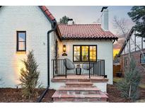 Charming home exterior features a red tile roof, black-trimmed windows, and cozy front porch at 450 S York St, Denver, CO 80209