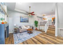 Bright living room featuring hardwood floors, a fireplace, and comfortable seating at 8199 Welby Rd # 4106, Denver, CO 80229