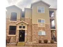 Tan three-story building with stone accents and multiple entrances at 17346 Nature Walk Trl # 201, Parker, CO 80134