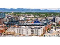 Stunning aerial view of Coors Field and the downtown Denver skyline with Rocky Mountain backdrop at 2150 Curtis St, Denver, CO 80205