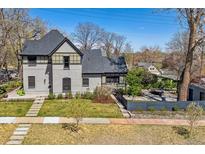 Charming two-story home boasts beautiful curb appeal and a well-manicured front yard with mature landscaping at 1002 Detroit St, Denver, CO 80206