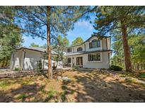 Beautiful two-story home featuring a modern design and situated in a serene wooded setting at 1935 Poncha Ct, Larkspur, CO 80118