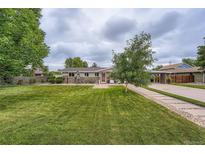 Charming single-story home with a well-manicured lawn, beautiful landscaping, and a welcoming entrance at 8455 W Belmar Ave, Lakewood, CO 80226