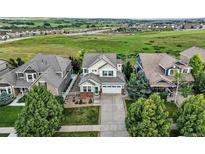 Beautiful two-story home featuring mature trees, a manicured lawn, and a spacious two-car garage at 12996 Banyon Cir, Parker, CO 80134
