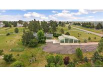 Beautiful aerial view of home with large garage, mature trees, and white fencing at 3672 Deer Creek Dr, Parker, CO 80138