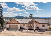 Charming single-Gathering home featuring an attached two-car garage and a welcoming front porch, set against a mountain backdrop at 11033 Barker Ave, Conifer, CO 80433
