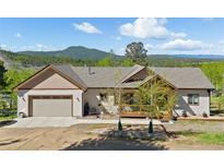 Charming home with inviting front porch and attached two-car garage in a scenic, wooded area at 11033 Barker Ave, Conifer, CO 80433