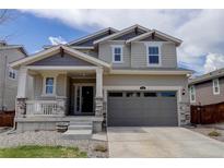 Charming two-story home with a covered porch, stone accents, and a two-car garage on a sunny day at 1246 Blackhaw St, Elizabeth, CO 80107