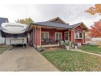 Red bungalow with porch, RV parking, and mature trees in the front yard at 103 S Park Ave, Fort Lupton, CO 80621