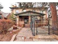 Brick two-story home with a stone path, wrought-iron fence, and landscaping at 471 N Humboldt St, Denver, CO 80218