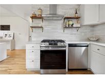 Modern kitchen features stainless steel appliances, white cabinets, and open shelving at 4419 W 34Th Ave, Denver, CO 80212