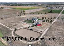 Expansive property with a home, red barn, outbuildings and horse riding area with farm fields surrounding at 10691 County Road 23, Fort Lupton, CO 80621