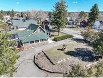 Charming home with lush green yard, water well feature, mature trees, and beautiful stone accents at 335 Jefferson St, Monument, CO 80132