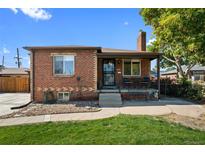 Brick ranch home with a landscaped lawn and a covered porch at 4747 Shoshone St, Denver, CO 80211