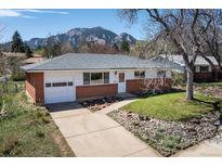Charming single-story home with brick accents, well-manicured lawn, and mountain views at 1275 Berea Dr, Boulder, CO 80305