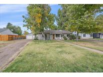 Ranch style home with a well-maintained lawn and mature trees at 5055 E Dartmouth Ave, Denver, CO 80222