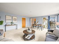 Bright living room featuring neutral color scheme, modern decor, and sliding glass doors to backyard at 10050 W 8Th Pl, Lakewood, CO 80215