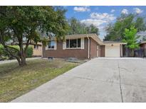 Charming brick home with a well-maintained front yard and a long driveway leading to a one-car garage at 3150 W Mexico Ave, Denver, CO 80219