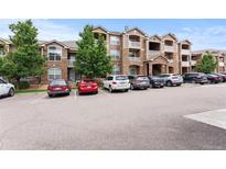 Exterior building shot showing the architectural details of this multi-story apartment complex with ample parking space at 7440 S Blackhawk St # 207, Englewood, CO 80112