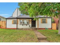 Charming home featuring a well-manicured lawn, quaint shutters, and a welcoming front entrance at 1325 Dayton St, Aurora, CO 80010