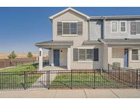 Charming townhouse featuring a well-maintained lawn, secure fence, and classic brick facade at 27752 E 1St Ave, Aurora, CO 80018