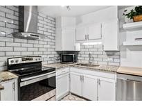 Updated kitchen featuring granite countertops, white cabinets, and stainless steel appliances at 705 S Alton Way # 6B, Denver, CO 80247