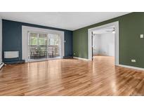 Open floor plan featuring living room, balcony access, and hardwood floors at 705 S Alton Way # 6B, Denver, CO 80247