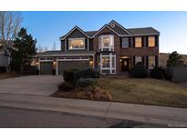 Charming two-story home featuring a three car garage, brick facade, and well-manicured front lawn at 310 S Snowmass Cir, Superior, CO 80027