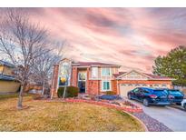 Beautiful two-story brick home with attached garage and manicured front lawn under a colorful sky at 11052 Zephyr St, Broomfield, CO 80021