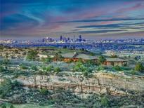 Stunning aerial view of the estate at dusk with city skyline in the background at 15175 W Belleview Ave, Morrison, CO 80465