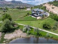 Stunning multi-story home featuring a manicured lawn and scenic views at 15175 W Belleview Ave, Morrison, CO 80465