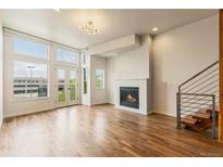 Bright living room featuring large windows, a modern fireplace, and hardwood floors at 2680 Blake St # 4, Denver, CO 80205