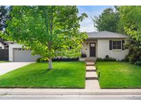 Charming one-story home featuring a lush green lawn and a classic painted brick exterior at 801 S Harrison St, Denver, CO 80209