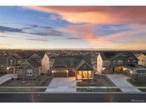 Charming single-Gathering home featuring solar panels, a two-car garage and covered front porch at dusk at 8751 S Wenatchee Ct, Aurora, CO 80016