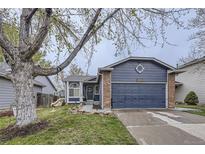 Charming blue home with a two-car garage, brick accents, and a well-maintained lawn at 5550 E 130Th Dr, Thornton, CO 80241