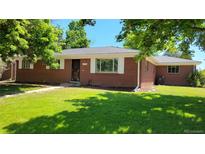 Brick ranch house with a well-maintained lawn and mature trees at 2998 S York St, Denver, CO 80210