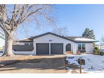 Ranch style home with gray and white exterior, two-car garage, and mature tree at 2538 S Dover Way, Lakewood, CO 80227