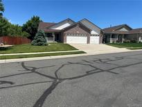 Charming two-story home with a three-car garage and a well-manicured lawn at 11237 W 55Th Ln, Arvada, CO 80002