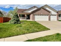Charming brick home featuring a two-car garage and well-manicured lawn at 11237 W 55Th Ln, Arvada, CO 80002