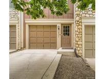 Inviting exterior featuring a brown garage door, matching front door, and stone accents at 8243 S Fillmore Cir, Centennial, CO 80122