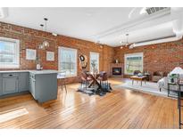 Bright open-concept living space boasts exposed brick, hardwood floors, a fireplace, and modern decor at 624 E 18Th Ave # 4, Denver, CO 80203