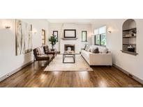 Inviting living room showcasing a fireplace, hardwood floors, and ample natural light at 1418 Glencoe St, Denver, CO 80220