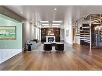 Spacious living room featuring a fireplace, stylish furniture, and a unique spiral staircase at 3131 E Alameda Ave # 1302, Denver, CO 80209