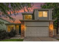 Charming two-story home with brick accents, attached garage, and beautiful sunset backdrop at 4710 N Foxtail Dr, Castle Rock, CO 80109