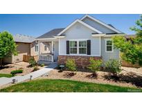 Charming single-story home with a well-maintained lawn, inviting porch, and brick accents on the front facade at 3678 Shadow Cir, Castle Rock, CO 80109