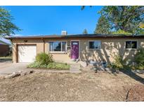 Charming brick home with a well-maintained front yard and a bright purple front door at 5183 W Columbia Pl, Denver, CO 80236