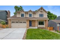 Charming two-story home featuring a brick and siding facade, well-manicured lawn, and a convenient two-car garage at 23 Honey Locust, Littleton, CO 80127